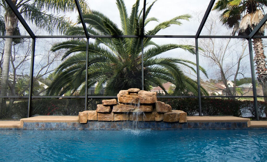 A beautifully designed pool showcasing water movement features for pools, with cascading waterfalls and vibrant landscaping.