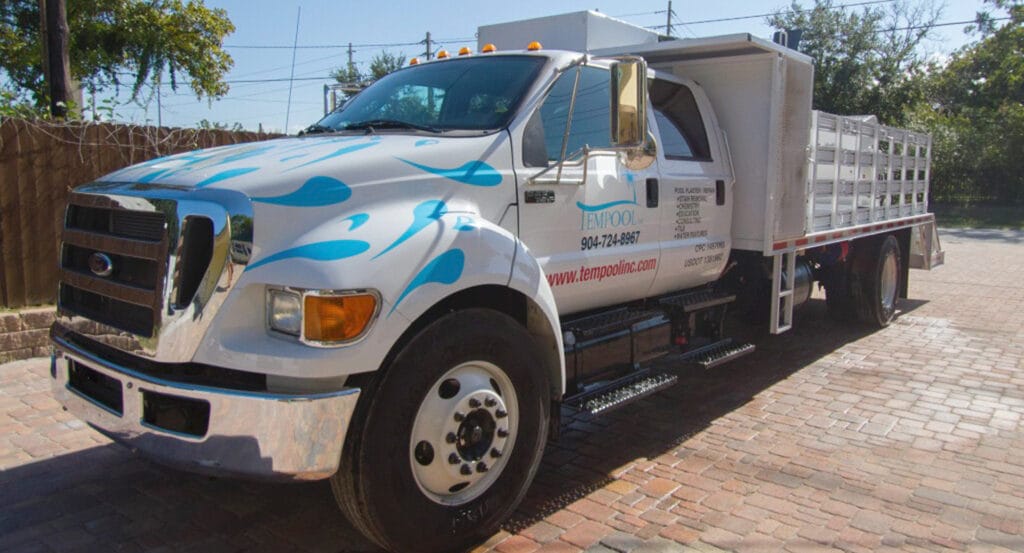 A truck loaded with pool renovation equipment parked outside, showcasing tools and materials for pool restoration.